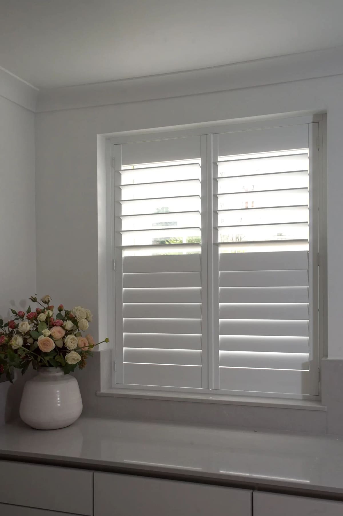 Full-height shutters with mid-rail on a sash window